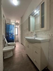 bagno con lavandino, servizi igienici e specchio di Four Seasons Apartment a Durrës