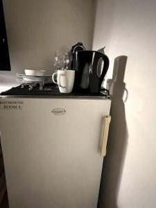 een witte koelkast met borden en keukengerei erop bij Room 404 - Eindhoven - By T&S. in Eindhoven