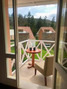 Habitación con vistas a un balcón con mesa y silla. en Aranwa Pueblito Encantado del Colca, en Coporaque
