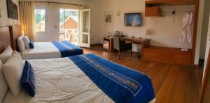 a hotel room with two beds and a desk and a desk at Aranwa Pueblito Encantado del Colca in Coporaque