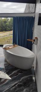a white bath tub sitting in a room with a window at Cabana Exclusivista Wild Spa Apuseni in Buceş-Vulcan