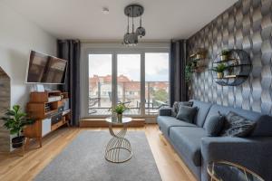 ein Wohnzimmer mit einem blauen Sofa und einem großen Fenster in der Unterkunft Luxurious living with beautiful terrace in Wien