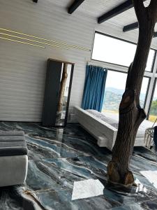 a room with a fake tree and a room with a floor at Cabana Exclusivista Wild Spa Apuseni in Buceş-Vulcan