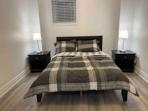 a bedroom with a large bed with two night stands at Adorable 2-Bedroom Basement with Sep Entrance in Ajax