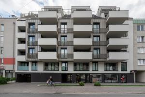 eine Person, die vor einem Gebäude Fahrrad fährt in der Unterkunft Luxurious living with beautiful terrace in Wien