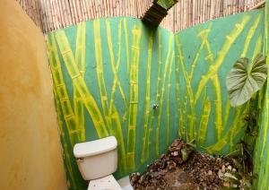 baño con aseo y una pintura de bambú en Cabaña Aguadulce, en San Rafael
