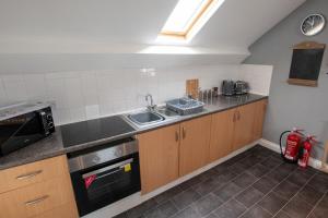 Una pequeña cocina con fregadero y estufa. en The Rafters, en Braunton