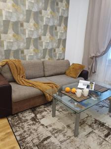 Una sala de estar con un sofá y una mesa de cristal. en City center Two room Apartment with One Bedroom, up to 5 Guests, SELF CHECK-IN, FREE parking, en Riga
