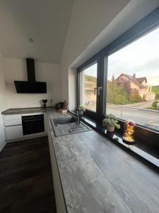 een keuken met een wastafel en een groot raam bij Penthouse in Bad Berleburg in Bad Berleburg