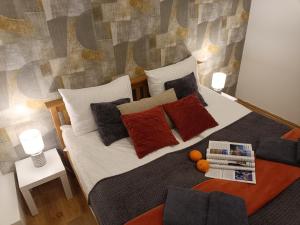 Un dormitorio con una cama con almohadas y naranjas encima. en City center Two room Apartment with One Bedroom, up to 5 Guests, SELF CHECK-IN, FREE parking, en Riga 32 fotos más