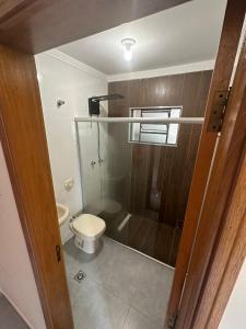 a bathroom with a toilet and a glass shower at Hospedagem Caconde Ar condicionado - Wi-fi - Garagem in Caconde