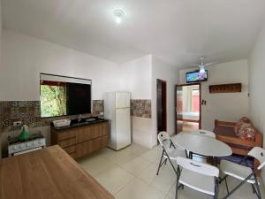 a kitchen and dining room with a table and a refrigerator at Residencial Porto di Lázaro in Ubatuba