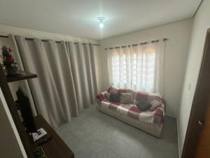 a living room with a couch in front of a window at Hospedagem Caconde Ar condicionado - Wi-fi - Garagem in Caconde