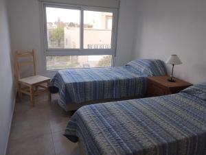 a hotel room with two beds and a window at La Baileyana. in Pringles