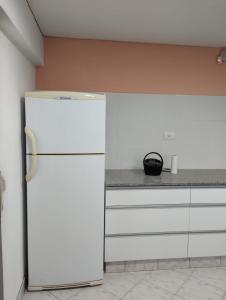 a kitchen with a white refrigerator in a room at La Baileyana. in Pringles +9 photos