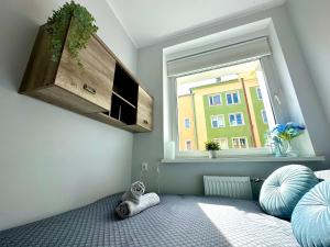 a bedroom with a window and a bed with a pillow at MMRent Citrus Room in Gdańsk