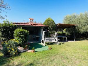 un jardín con banco y cenador en Casa in campagna Il Colibrì, en Sacrofano