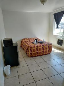 ein Schlafzimmer mit einem Bett auf einem Fliesenboden in der Unterkunft Crown Inn & Suites in Spring Valley