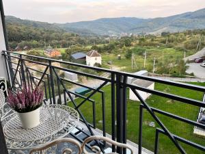 balcón con mesa y vistas a las montañas en Апартаменти в Arena Apart en Polyana