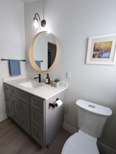 een badkamer met een wastafel en een spiegel en een toilet bij Stunning lakefront 4 season cottage in PEC in Bongard