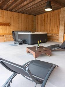 a chair and a table and a tv in a room at Les Séchoirs piscine et spa privatifs in Saint-Romans