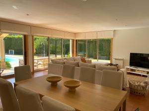 sala de estar con mesa de madera y sillas en Casa do Lago, Privacidade e Beleza Natural, en Esposende
