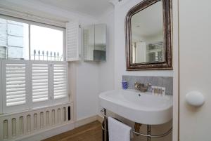 a bathroom with a sink and a mirror at Elegant Apartment near Portobello Road Market in London