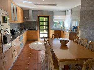 een keuken met een houten tafel en een eetkamer bij Casa do Lago, Privacidade e Beleza Natural in Esposende