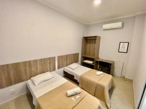 a small room with two beds and a stove at Hotel Smart in Mogi-Mirim