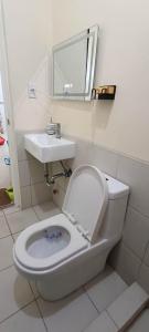 a bathroom with a toilet and a sink at CityLofts Plainview in Mandaluyong corner unit in Manila