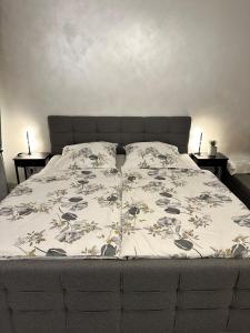 Una cama con una manta y dos mesas. en FeWo SKY21 * Langen EXKLUSIVES APPARTMENT Vollausstattung / zentrale Lage *NEU*, en Langen