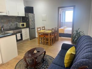 a kitchen and a living room with a couch and a table at The Sunset in Arco da Calheta