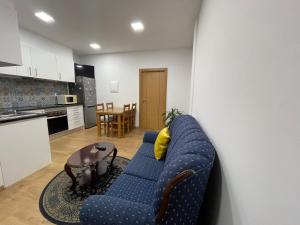 a living room with a blue couch and a table at The Sunset in Arco da Calheta