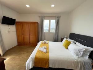a bedroom with a large bed with towels on it at The Sunset in Arco da Calheta