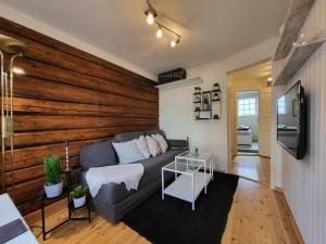 a living room with a couch and a wooden wall at Mars Modern and Cozy Apartment in the centre, Free Parking in Trondheim