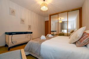 een slaapkamer met een groot wit bed en een spiegel bij ÁGORA in El Burgo de Osma