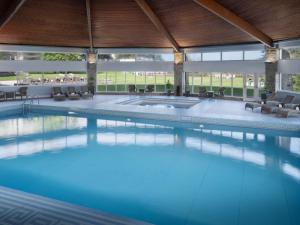 a large swimming pool in a large building at Delta Hotels by Marriott St Pierre Country Club in Chepstow