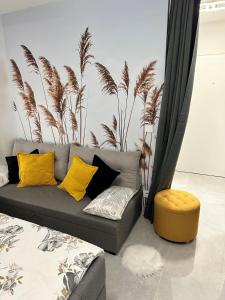sala de estar con sofá gris y almohadas amarillas en FeWo SKY21 * Langen EXKLUSIVES APPARTMENT Vollausstattung / zentrale Lage *NEU*, en Langen