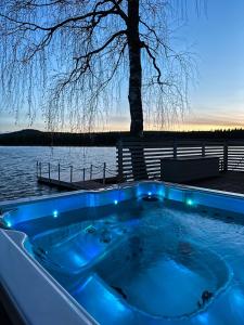 une baignoire jacuzzi installée à côté d'une étendue d'eau dans l'établissement Luxurious Villa Kinos with Jacuzzi, à Rovaniemi