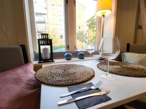 a table with two plates and wine glasses on it at Mars Modern and Cozy Apartment in the centre, Free Parking in Trondheim