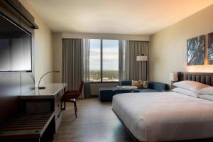 ウィンストン・セーラムにあるWinston-Salem Marriottのベッドと大きな窓が備わるホテルルームです。
