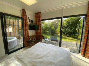 1 dormitorio con 1 cama y balcón con bañera en JANUS COUNTRY SITE Üdülőházak, en Szakcs