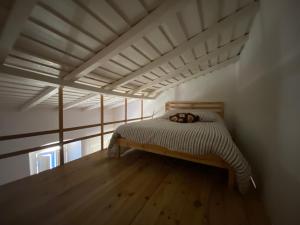 a bed in a room with a wooden floor at Casa na aldeia in Albernoa