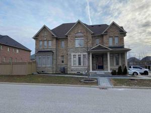 a large brick house with a car parked in front of it at Adorable Ajax House for Rent in Ajax