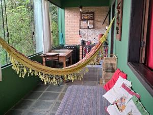 a hammock in a room with a table and chairs at Poente Guest House in Conceição da Ibitipoca