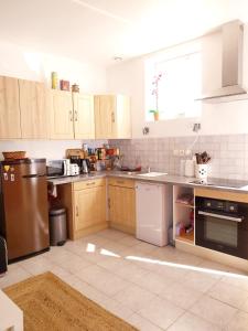 a kitchen with wooden cabinets and stainless steel appliances at Gîte-appartement sur la Côte d'Emeraude in Beaussais sur Mer +12 photos