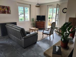 a living room with a couch and a tv at le gite du Montcalm in Auzat