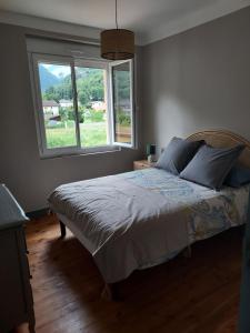 a bedroom with a bed with a large window at le gite du Montcalm in Auzat