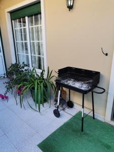 a black piano sitting outside of a house with plants at Por A Mor in Figueiró dos Vinhos