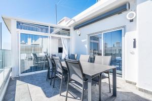 ein Esszimmer mit einem Tisch und Stühlen auf dem Balkon in der Unterkunft New Luxury Penthouse beachfront in the Algarve in Armação de Pêra